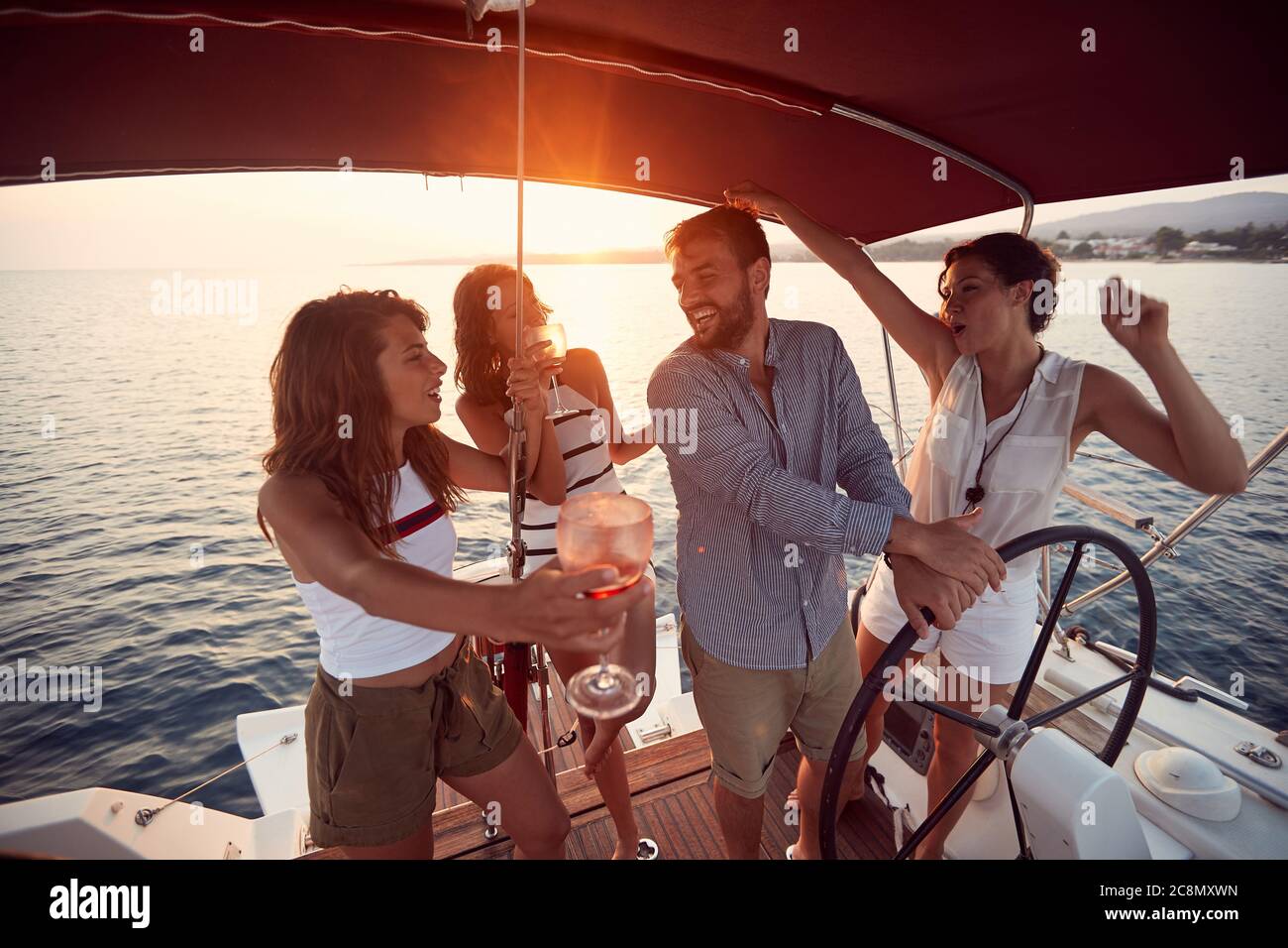 Groggy Freunde auf einer Yacht genießen den Sonnenuntergang und ein wunderbares Wetter Stockfoto