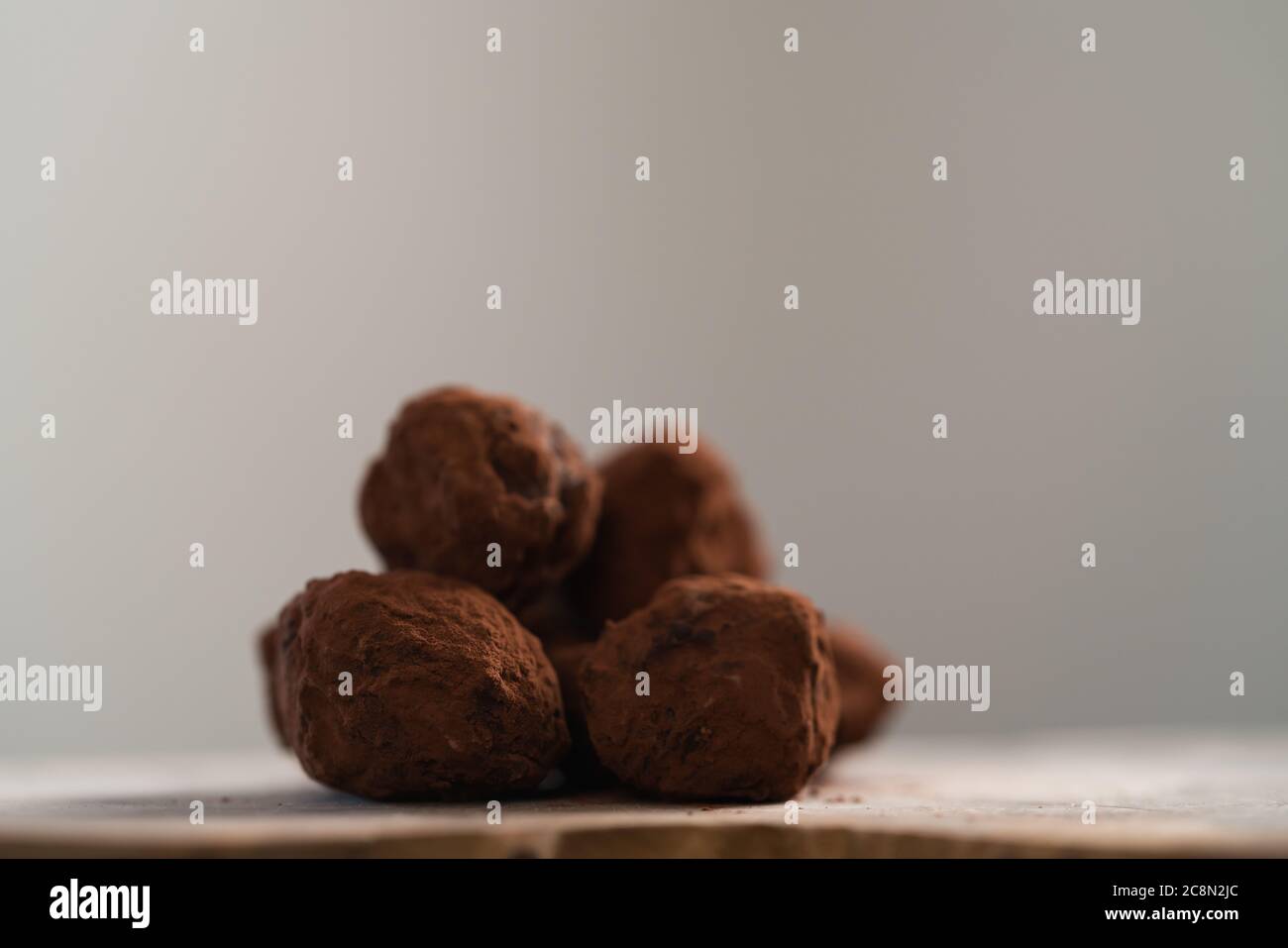 Handgemachte Schokoladentrüffel auf olivfarbenem Brett Stockfoto