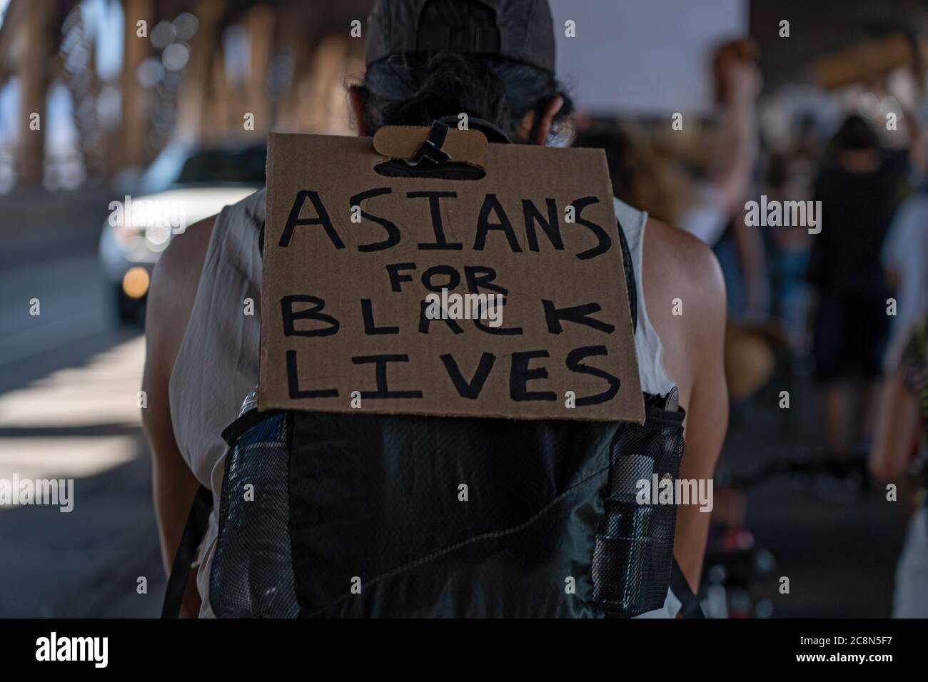 NEW YORK, NY – 25. JULI: Ein Protestler mit einem Schild, auf dem steht: „Asians for Black Lives“, fährt während eines marschfahrens über die Queensboro Bridge Stockfoto