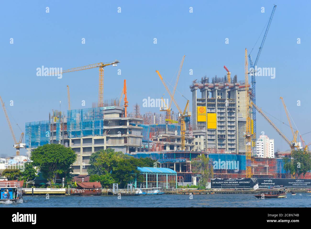 BANGKOK, THAILAND - 12. DEZEMBER 2016: Bau moderner Hochhäuser am Ufer des Chao Phraya Flusses Stockfoto