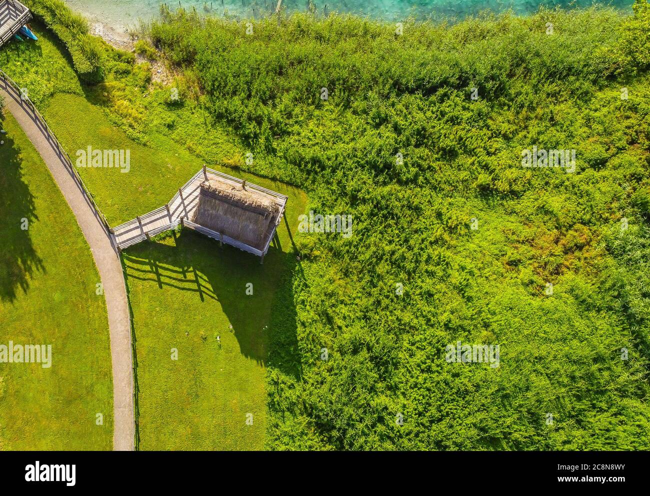 Ledro See, Italien. Rekonstruierte Hütten auf Stelzen, um das Leben in der prähistorischen Zeit zu zeigen. Blick auf den See und archäologische Gegend. Eine UNESCO-Welt Stockfoto