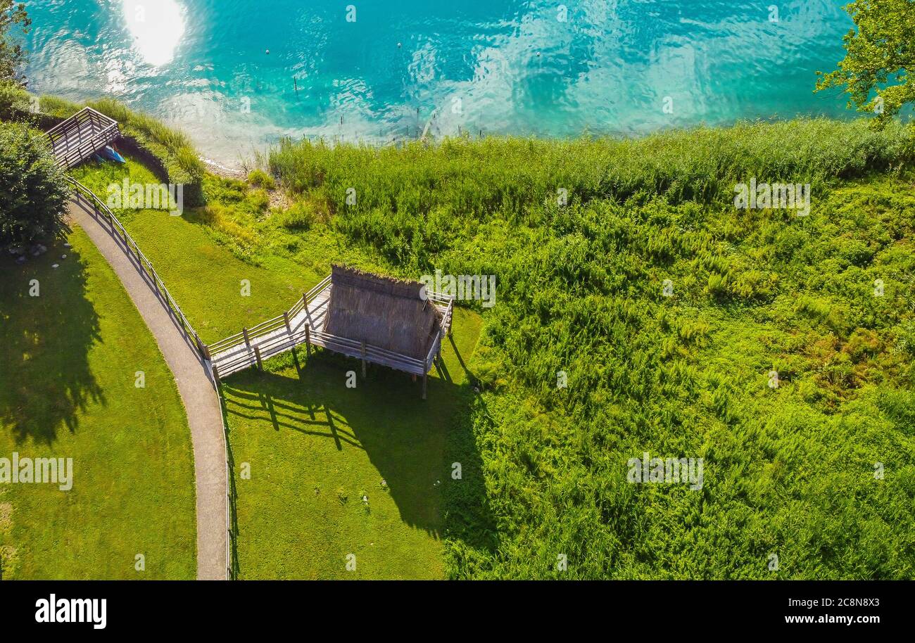 Ledro See, Italien. Rekonstruierte Hütten auf Stelzen, um das Leben in der prähistorischen Zeit zu zeigen. Blick auf den See und archäologische Gegend. Eine UNESCO-Welt Stockfoto