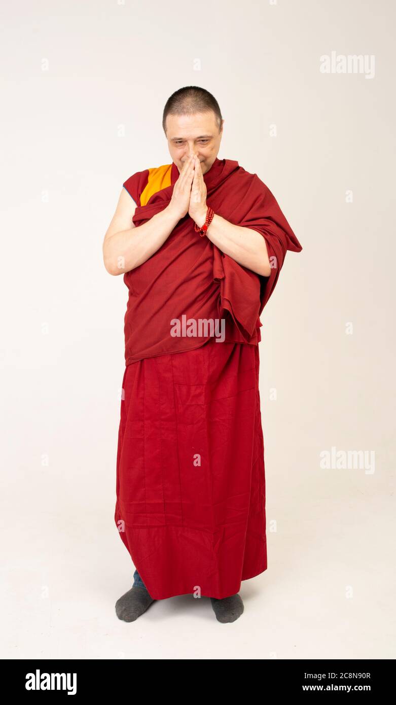 lama Mönch faltete seine Handflächen und rezitieren ein Mantra. Monakh ist in einem roten Lama-Outfit gekleidet Stockfoto