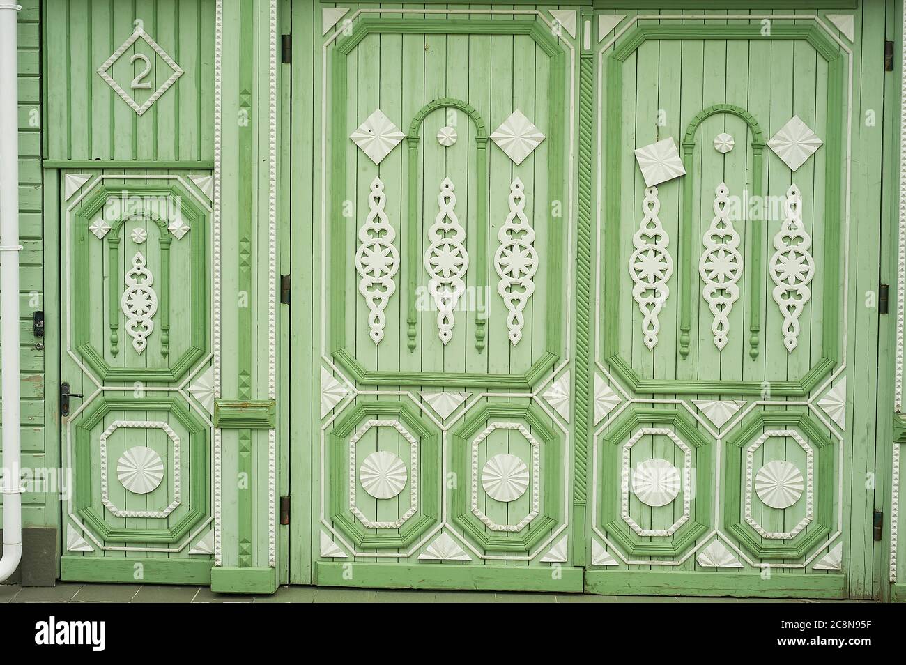 Hölzerne breite Tore in alten russischen Häusern. Figurative Ornamente aus Holz.Helle Farben. Alte russische Holzhäuser. Stockfoto