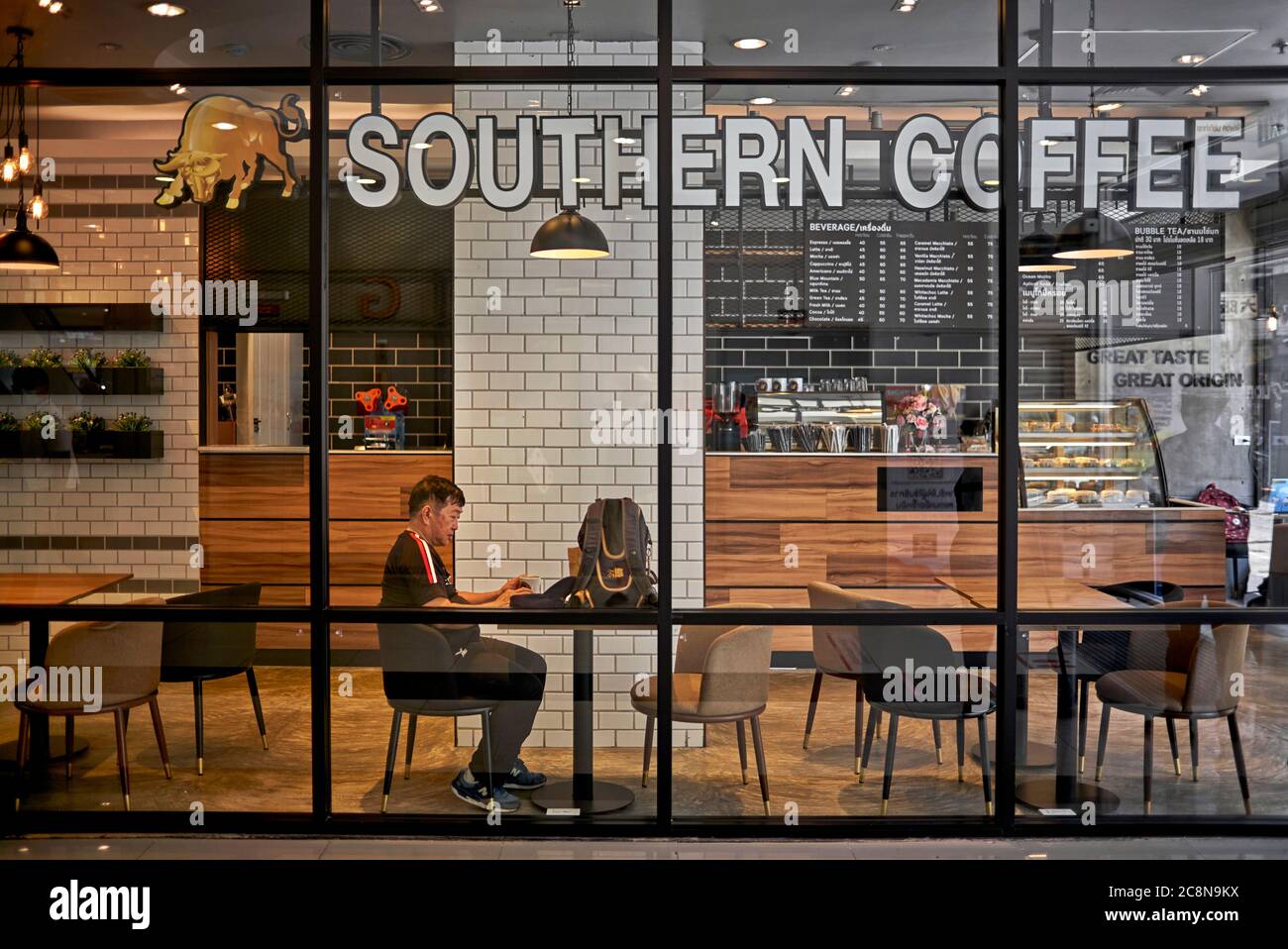 Mann allein, der in einem leeren Café sitzt. Thailand, Südostasien Stockfoto