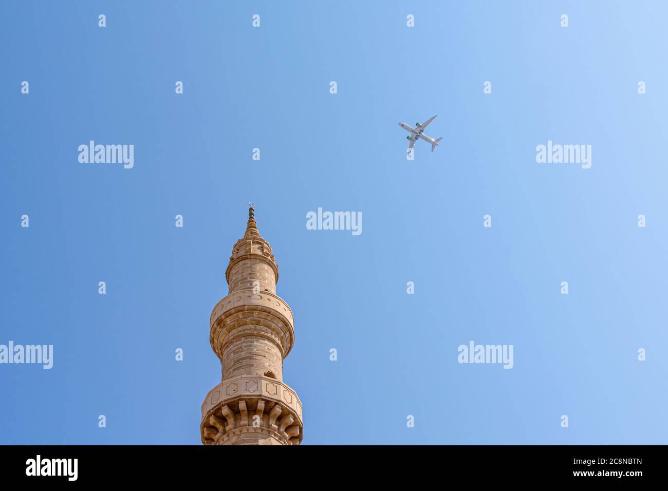 Ein Flugzeug fliegt über das Minarett der Moschee von Suleiman in der alten Rhodos-Stadt, Griechenland Stockfoto