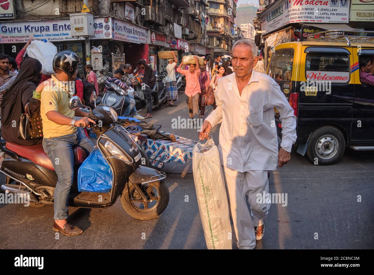 Zwei Männer steuern einen Handwagen durch die geschäftige Kalbadevi Rd. In Bhuleshwar, Mumbai, Indien, Handkarren, die die am meisten verwendete Modus für den Güterverkehr in der Gegend Stockfoto