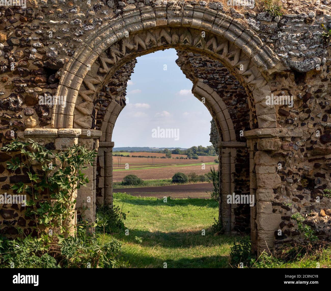 Blick durch die gewölbte Tür der Ruinen der Kirche aus dem 11. Jahrhundert in Bawsey. Stockfoto