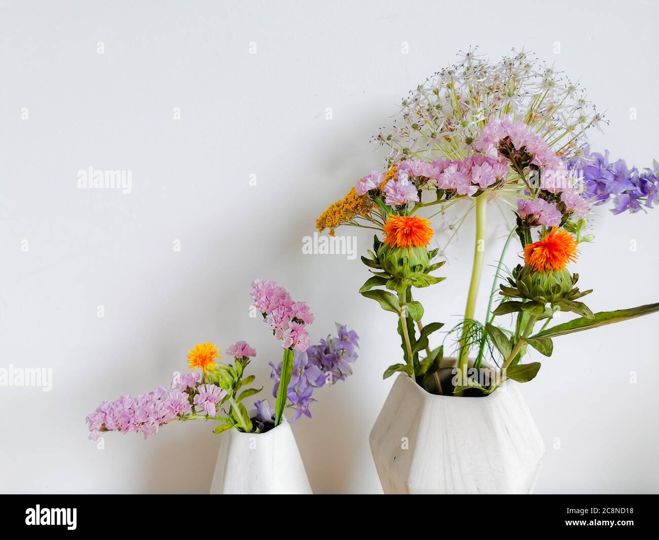 Kleiner Blumenstrauß aus wilden Frühlingsblumen in Vasen aus faux Marmor Stockfoto