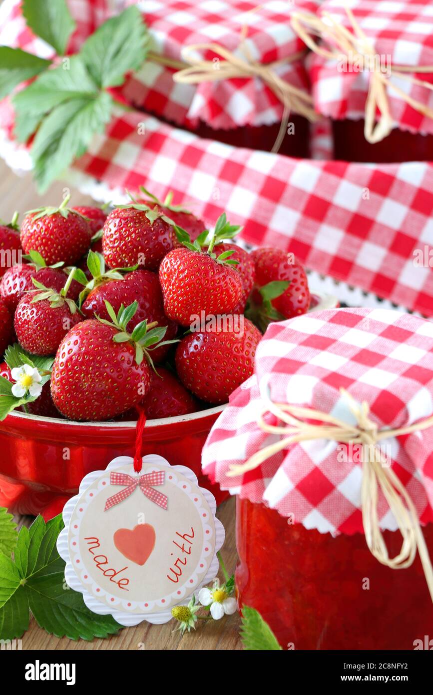 Erdbeermarmelade im Glas und frische Erdbeeren in einer Schüssel Stockfoto