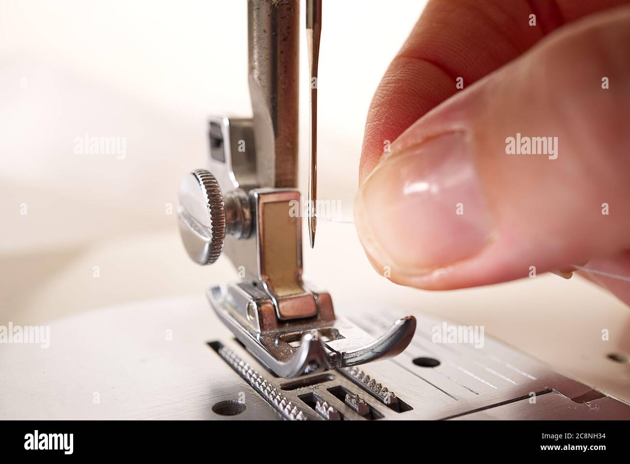 Frau, die eine Nadel auf einer Nähmaschine einfädeln. Nahaufnahme,  selektiver Fokus Stockfotografie - Alamy