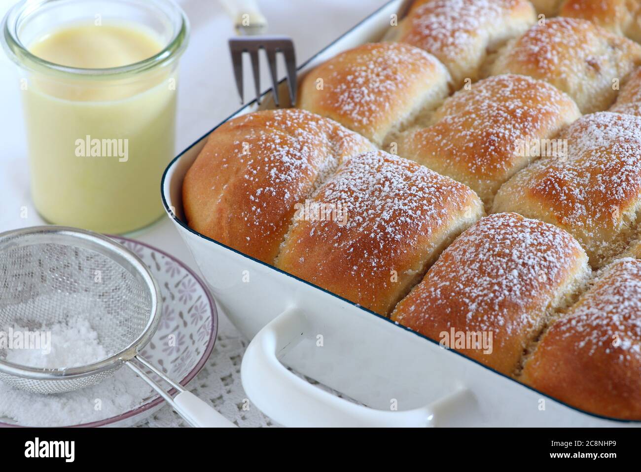 Im Ofen gebackene Hefeknödel mit Vanillesoße Stockfoto