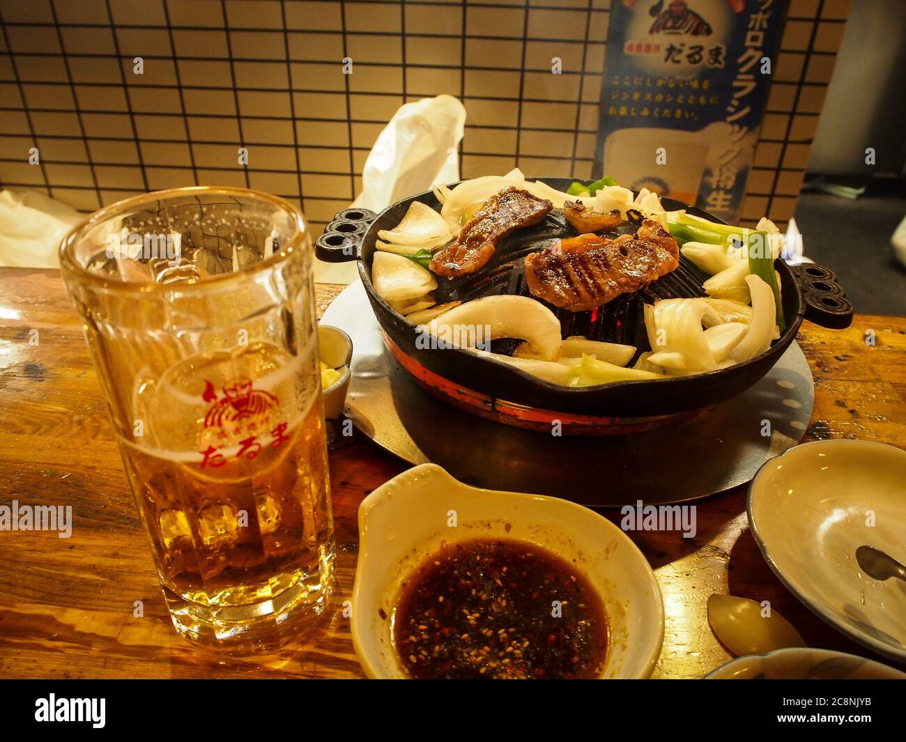 Susukino, Sapporo, Hokkaido, Japan - Jingisukan oder Dschingis Khan, ein japanisches gegrilltes Hammelgericht, das auf einer konvexen Metallpfanne oder einem anderen Grill zubereitet wird. Stockfoto