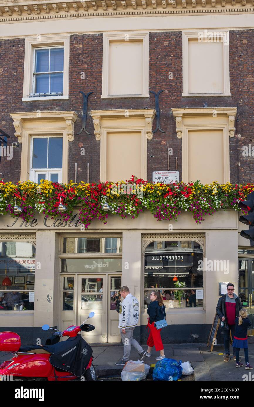 Das Straßenschild der Portobello Road prominent auf der Außenseite des Castle Pub, Notting Hill, London - dekoriert mit bunten Pflanzen. Stockfoto