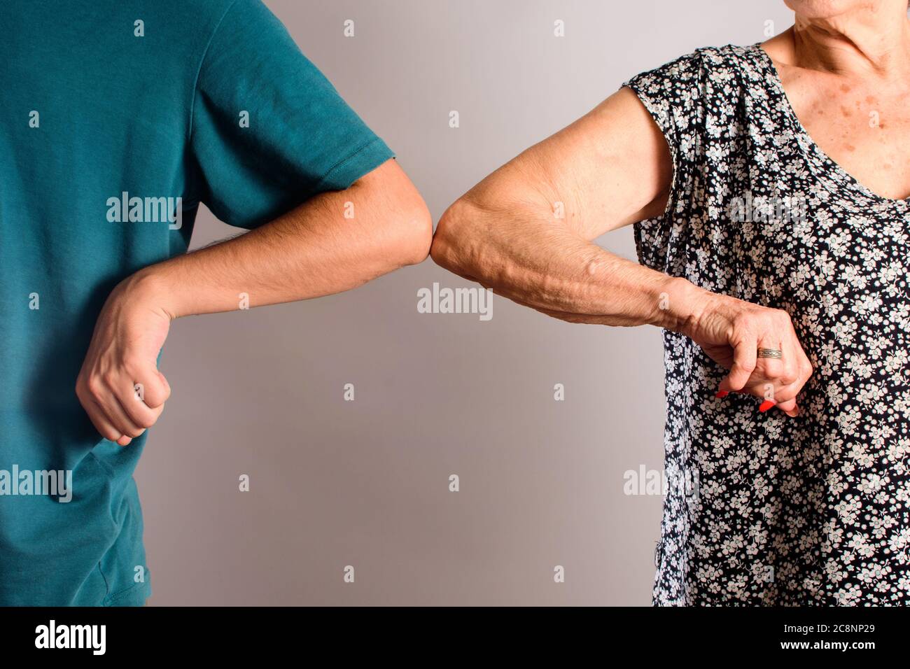 Person winkt Ellbogen mit seiner Großmutter Gruß zusammen von neu Stil, um Coronavirus zu verhindern Stockfoto