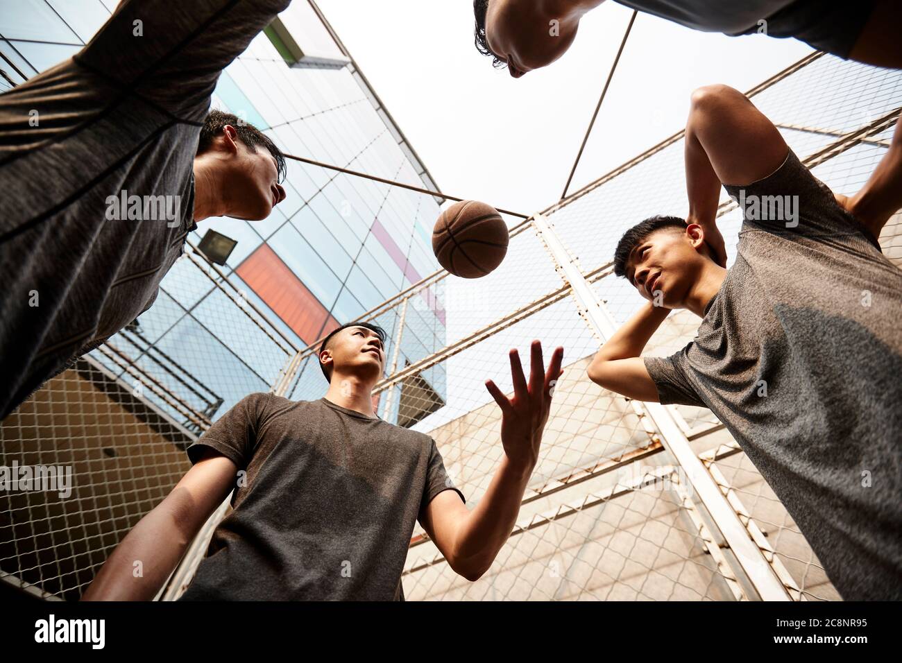 Junge asiatische Erwachsene Männer mit Spaß spielen mit Basketball im Freien Stockfoto