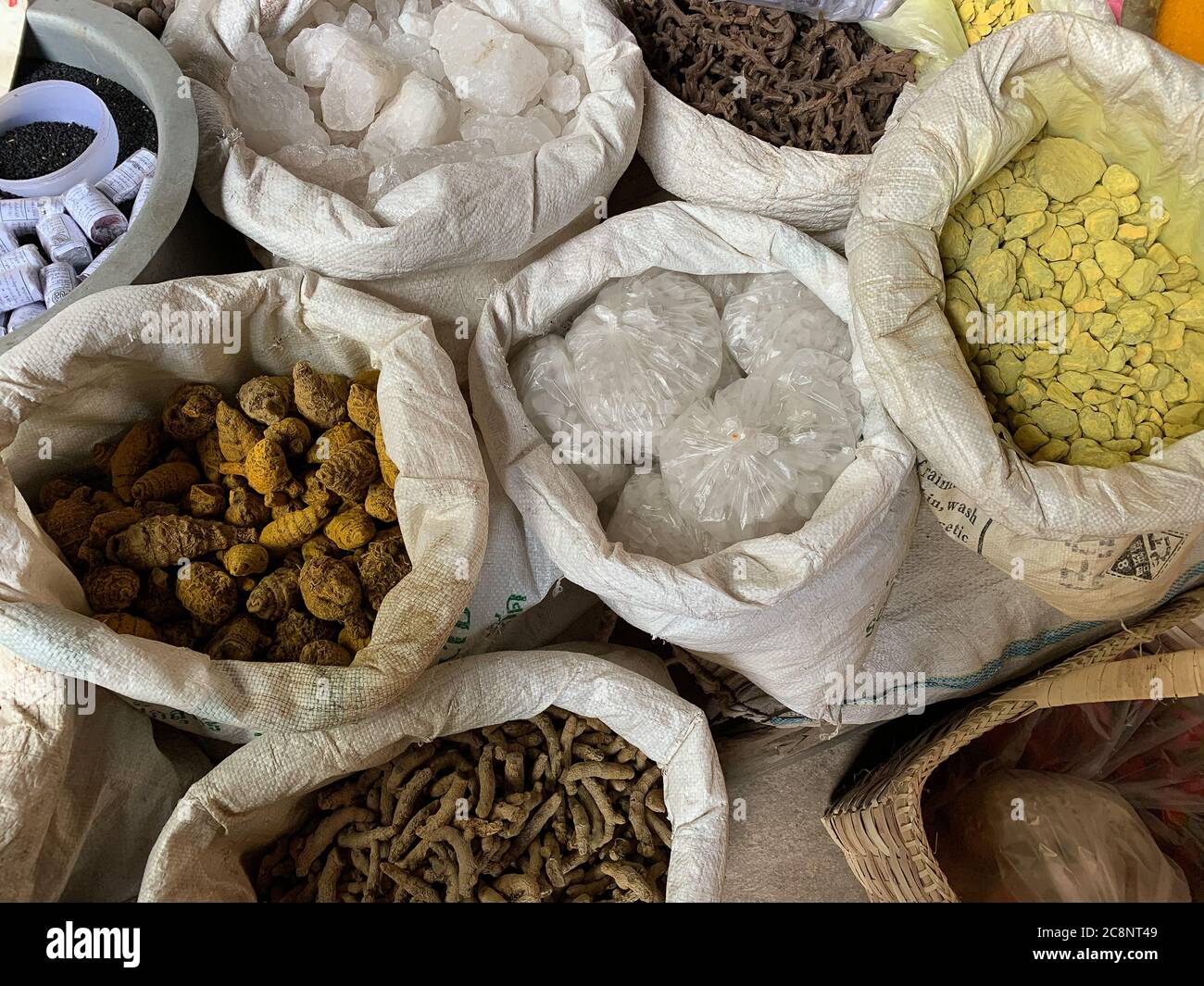 Weiße hessische Säcke mit typischen asiatischen Gewürzen und Wurzelgemüse, auf dem birmanischen Markt zu sehen Stockfoto