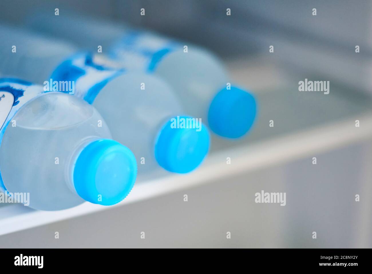 Flaschen mit kaltem Wasser im Kühlschrank, Nahaufnahme Stockfoto