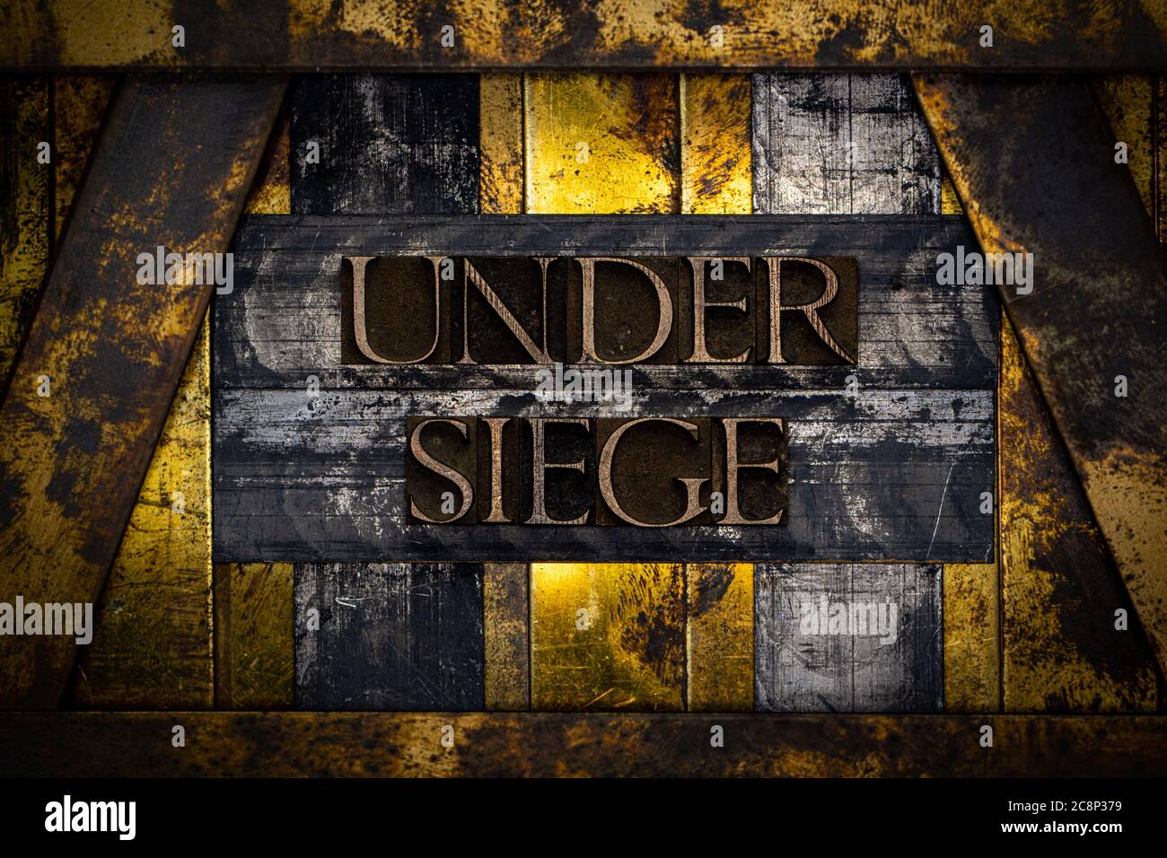 Unter Belagerung Text gebildet mit echten authentischen Schriftsatz Buchstaben auf vintage texturierten Silber Grunge Kupfer und Gold Hintergrund Stockfoto