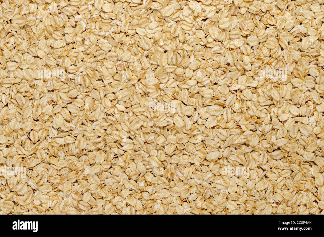 Hafer, Oberfläche und Hintergrund gerollt. Leicht verarbeitete Vollkornprodukte. Geschälte und gedämpfte Hafergroats werden zu Flocken gerollt und leicht geröstet. Stockfoto