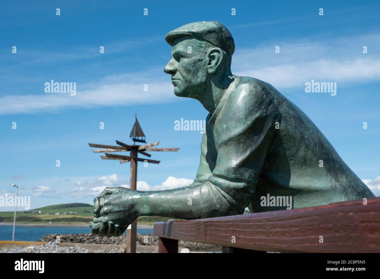 Eine Skulptur von Andrew Brown eines Fischers, der im schottischen Fischerdorf Port William, Dumfries und Galloway auf das Meer blickt. Stockfoto