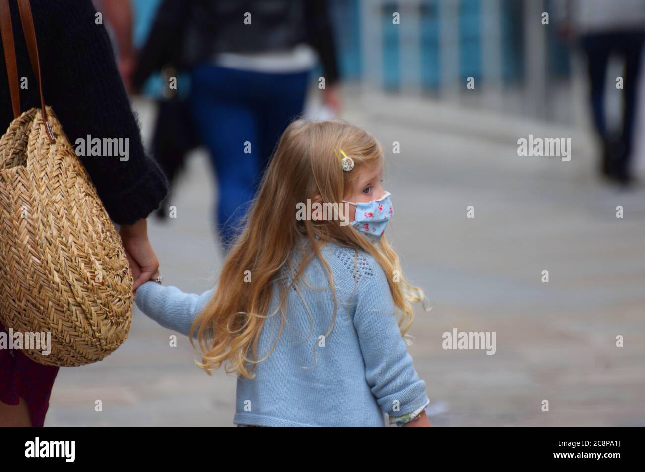 Ein kleines Mädchen im Alter von ca. 5 Jahren trägt eine Gesichtsmaske in der Öffentlichkeit in England nach einem Gesetz verabschiedet, die das Tragen von Gesichtsbedeckungen obligatorisch in Geschäften Stockfoto