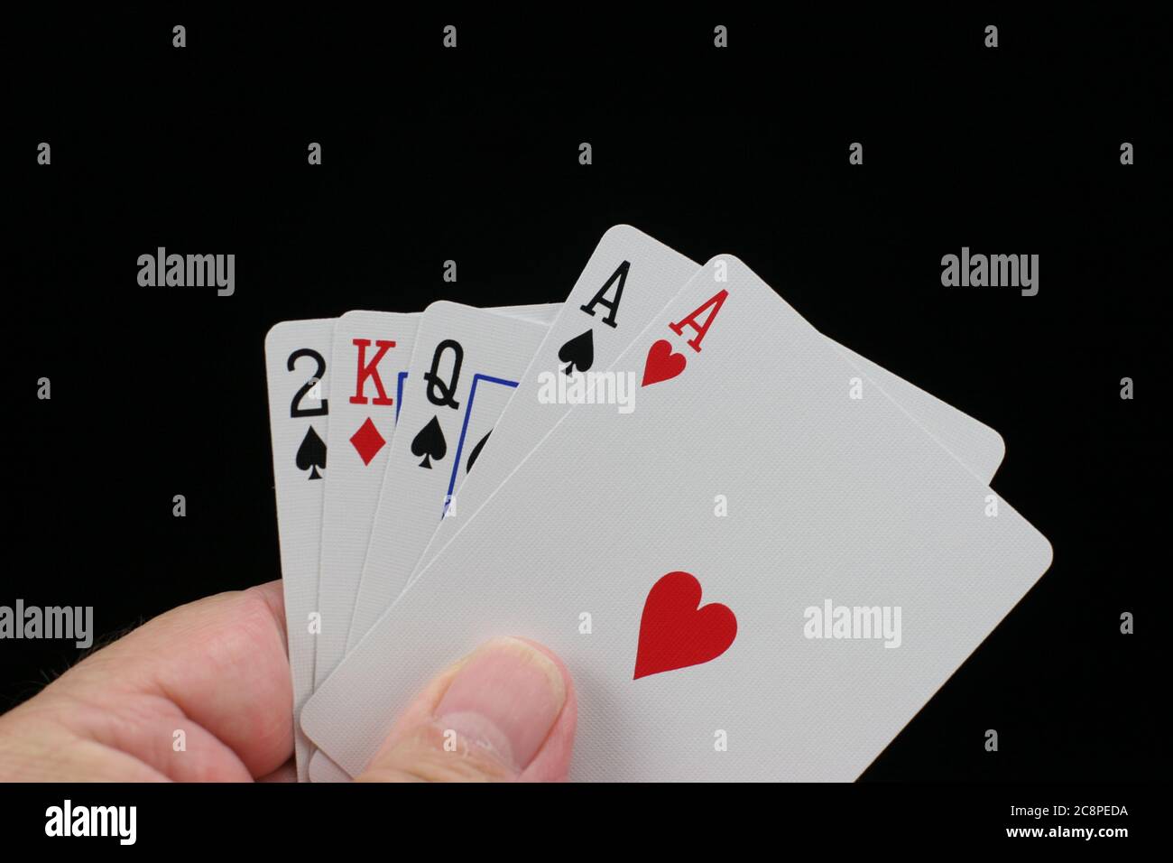Hand hält Poker Spielkarten auf schwarzem Hintergrund. Stockfoto