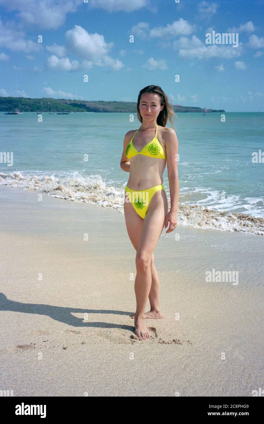 Lächelnd hübsche Hündin mit langen Haaren im Bikini stehend am kuta Strand bali indonesia 2002 Stockfoto