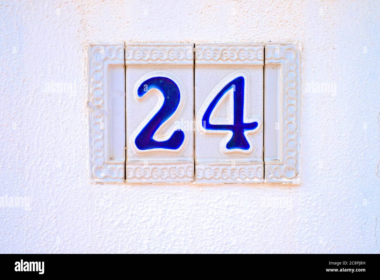 24, Nummer vierundzwanzig, blaue Zierziffern auf weißer Oberfläche. Stockfoto