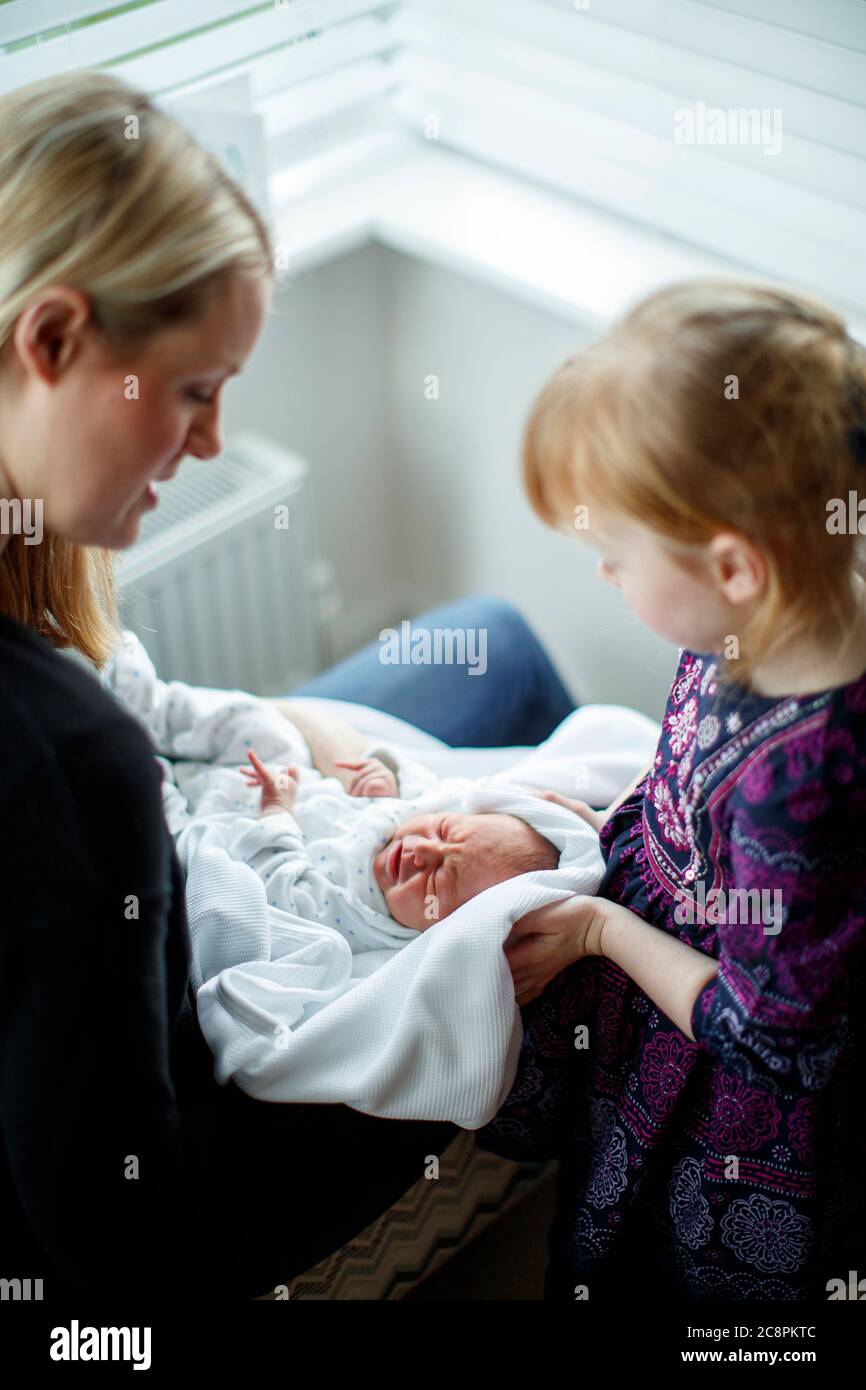 Mutter und Tochter kümmern sich um neugeborenes Baby Stockfoto