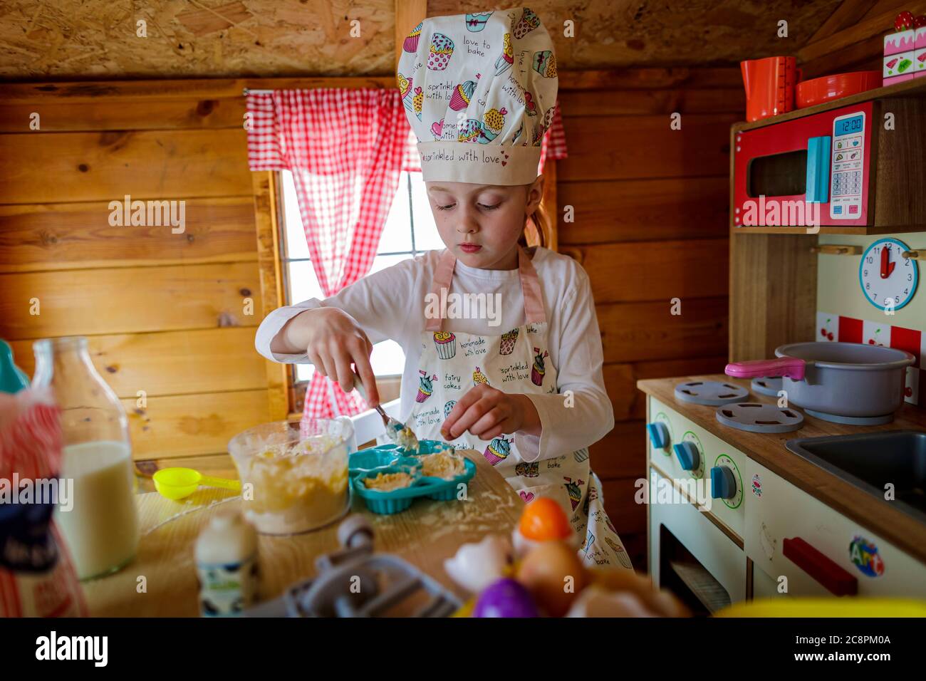 Junges Mädchen in wendy Haus vorgibt, in der Küche zu kochen Stockfoto