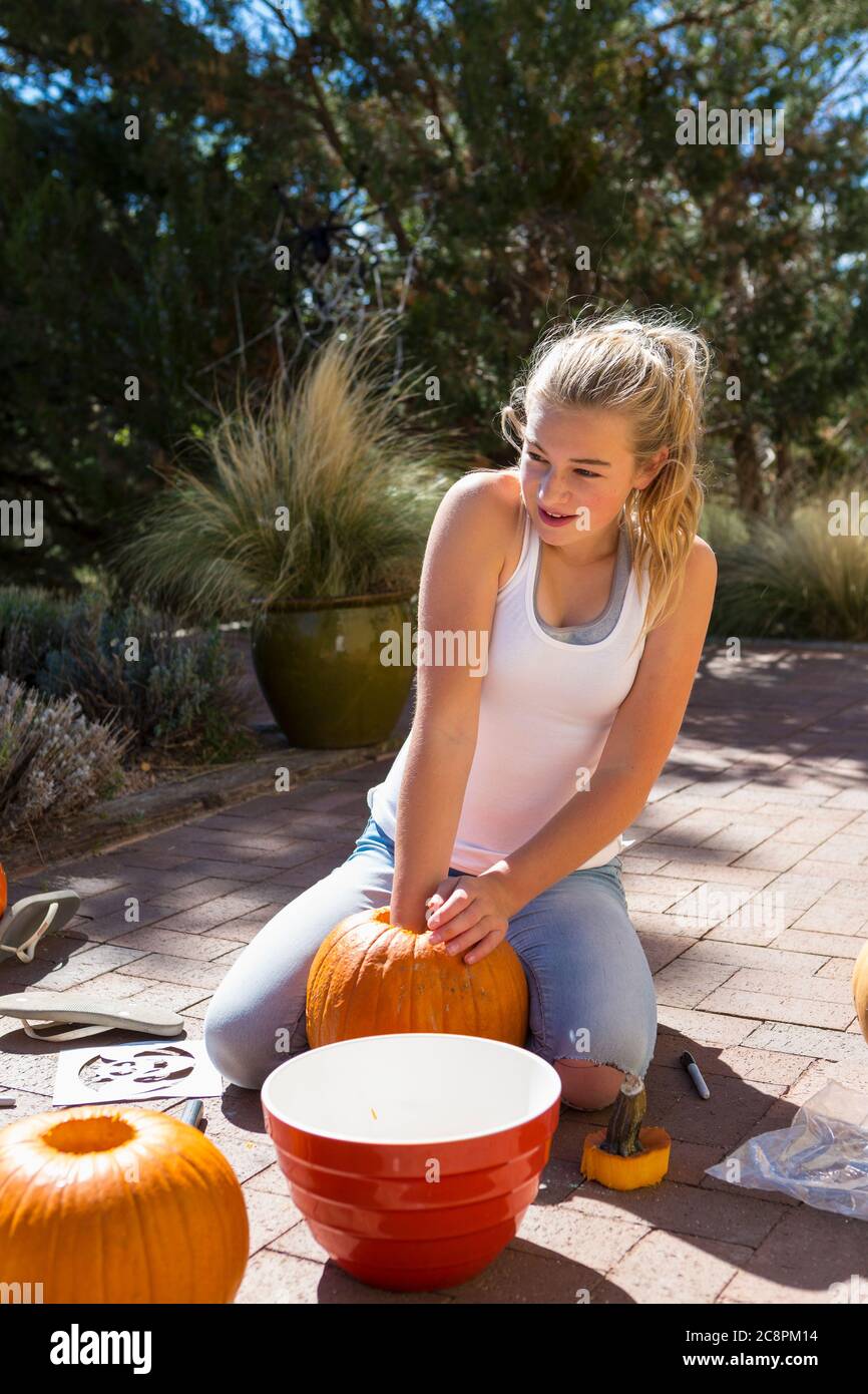 11-jähriges Mädchen, das einen Kürbis ausgräbt Stockfoto