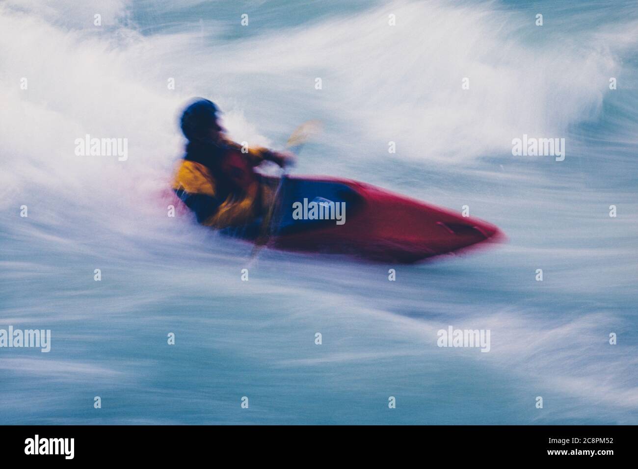 Lange Exposition der männlichen Wildwasser-Kajakfahrer paddeln und Surfen großen Stromschnellen auf einem schnell fließenden Fluss. Stockfoto