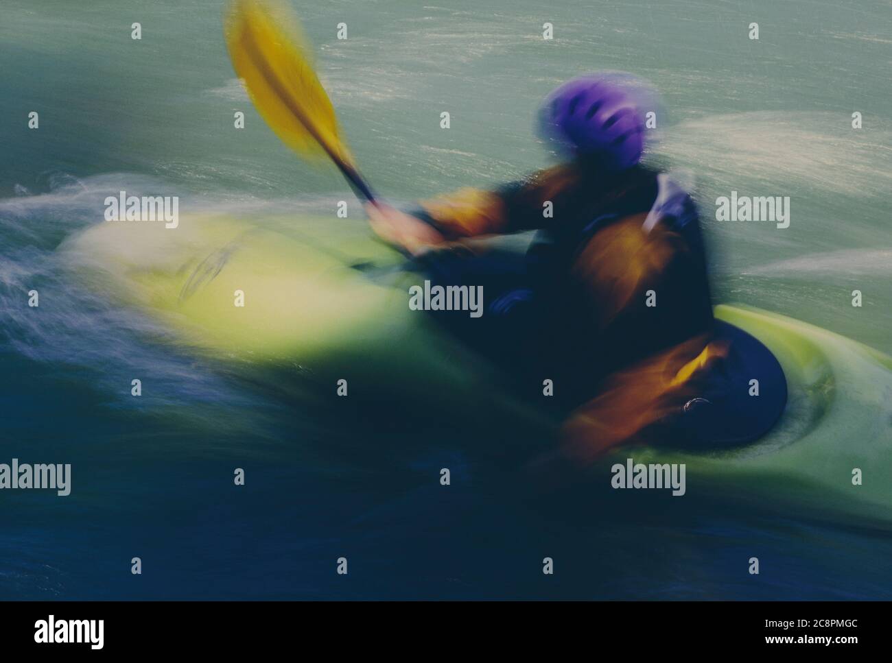 Lange Exposition von weiblichen Wildwasser Kajakfahrer paddeln Stromschnellen und surfen auf einem schnell fließenden Fluss. Stockfoto