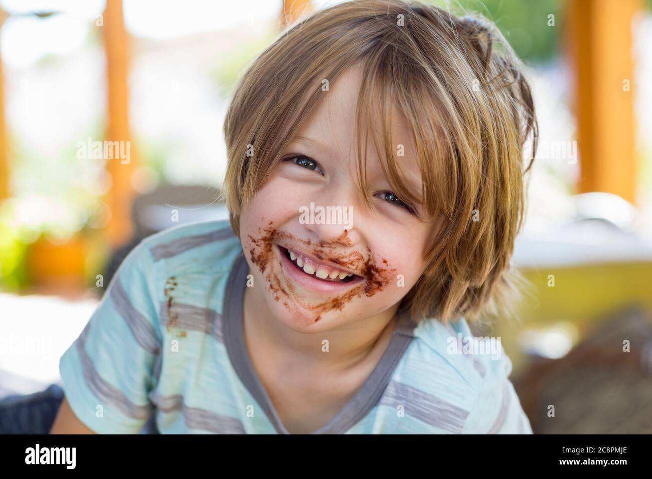Portrait von lächelndem 4-jährigen Jungen mit Schokolade auf seinem Gesicht spielen mit älteren Schwester Stockfoto