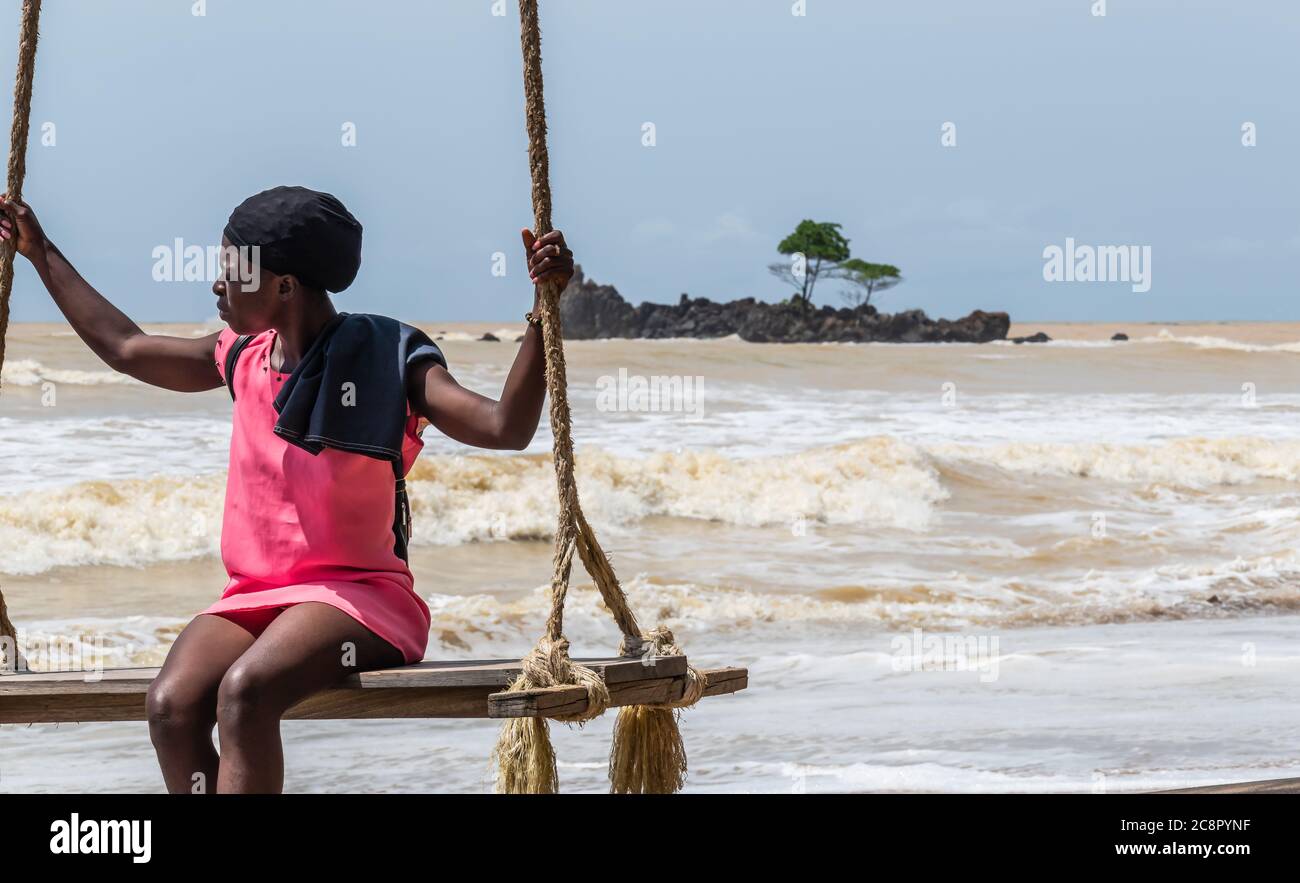 Afrikanische Frau sitzt am Meer auf einem Hängesessel. Axim Ghana Westafrika Strand Stockfoto