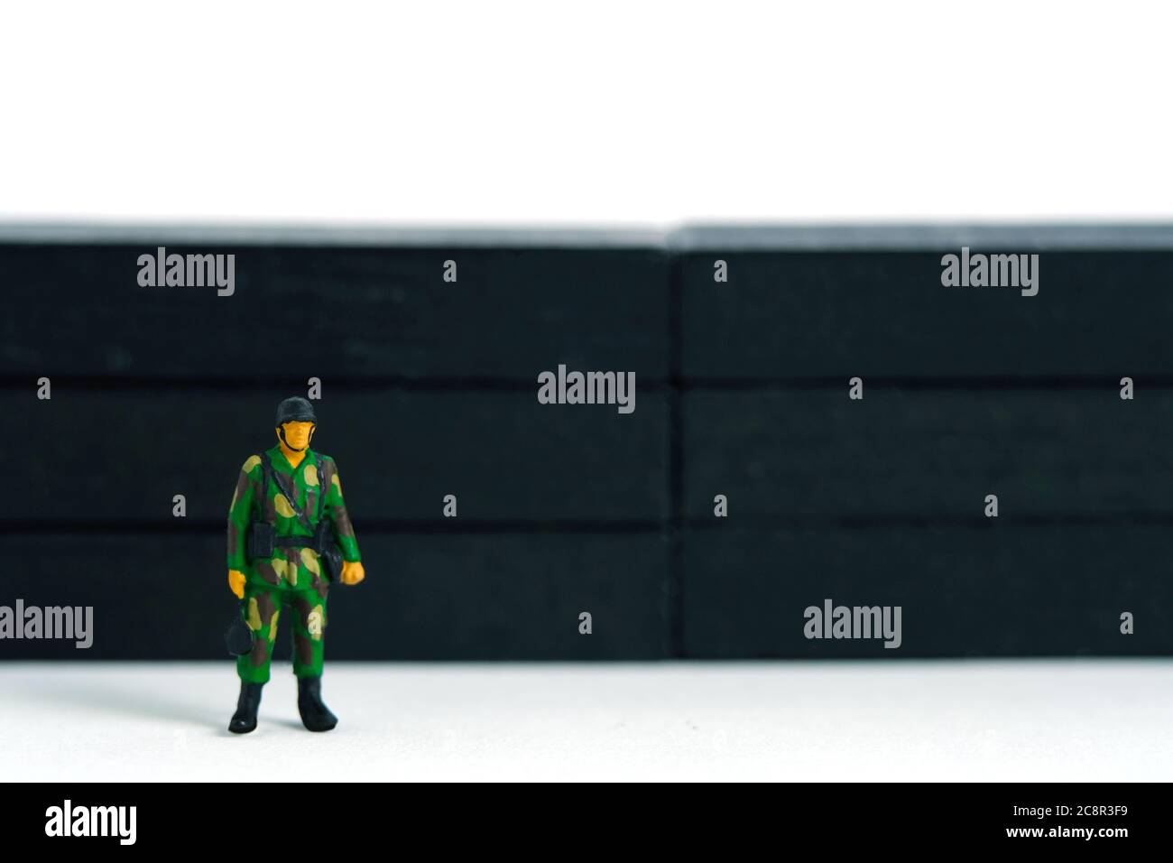 Pandemie Coronavirus konzeptuelle Miniatur-People-Fotografie – Lockdown-Illustration – Miniatur-Soldat stehen Wache vor der Barriere Wand. Bild P Stockfoto