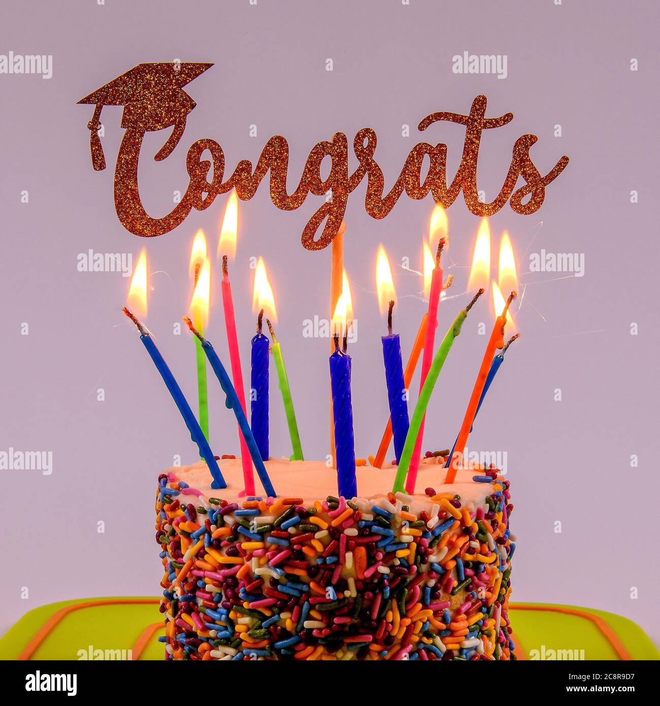Ein Kuchen mit Kerzen, die eine Abschlussfeier feiern. Stockfoto
