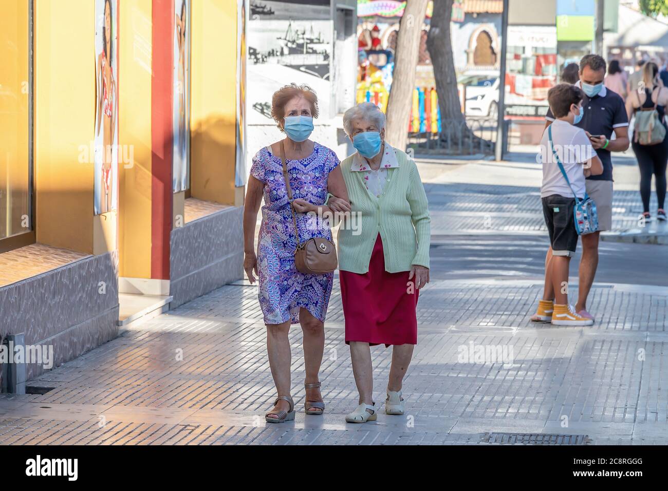 Punta Umbria, Huelva, Spanien - 10. Juli 2020: Zwei ältere Frauen, die auf der Straße mit Schutzmaske wegen covid-19. Neue Normalität in Spanien Stockfoto