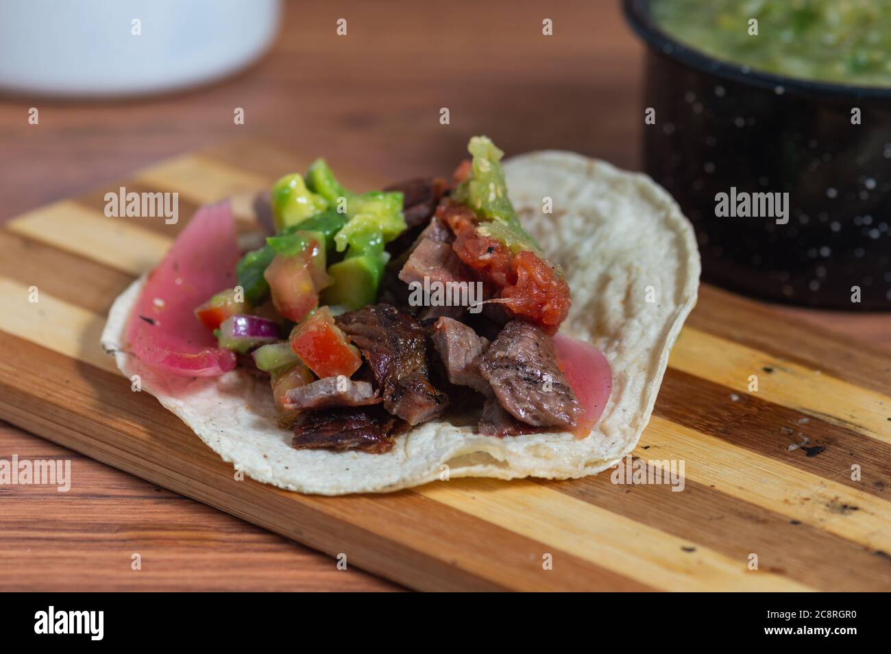 Mexikanisches Barbecue, Tacos von Carne Asada und Chorizo mit Guacamole und hausgemachten Salsas Stockfoto