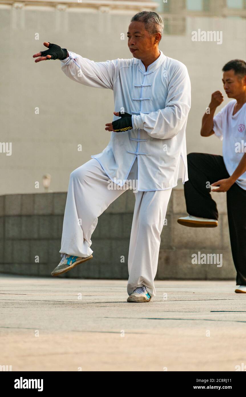 Tai Chi Übungen am Denkmal für die Helden des Volkes am Ufer des Bund von Shanghai früh am Morgen. Stockfoto