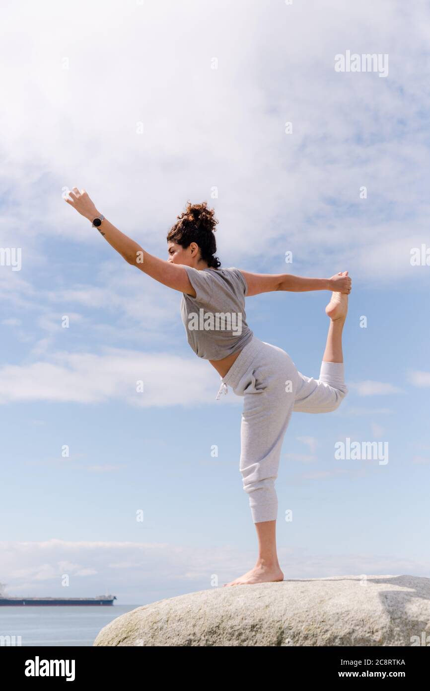 Junge Frau, die Yoga-Posen macht Stockfoto
