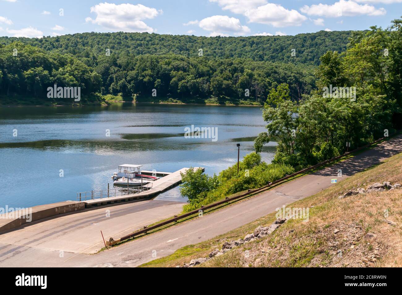 Ein Freizeitboot, das an einem sonnigen Sommertag am Fuße einer Rampe am Tionesta-See, Forest County, Pennsylvania, USA, an einem Dock festgebunden ist Stockfoto