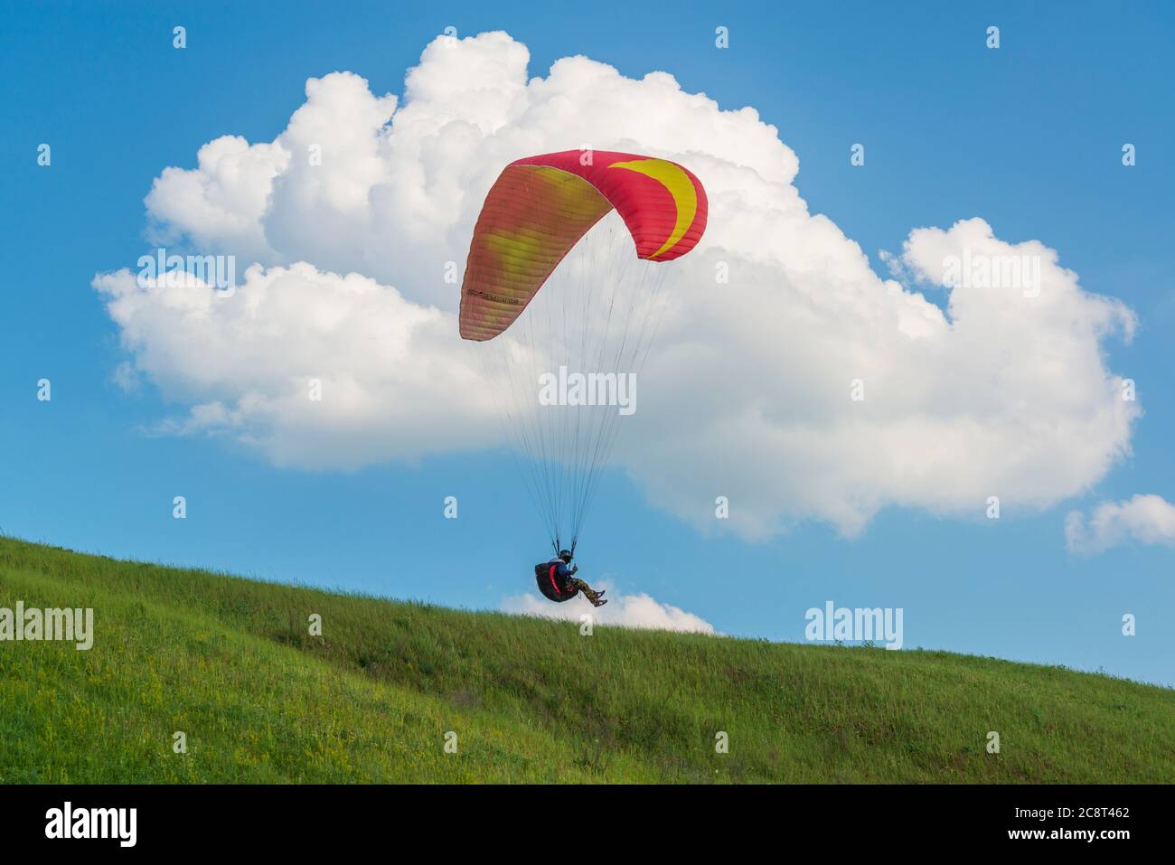 2017-06-25, Kiew, Ukraine. Rote Gleitschirmflieger Silhouette am Himmel mit Wolken Stockfoto