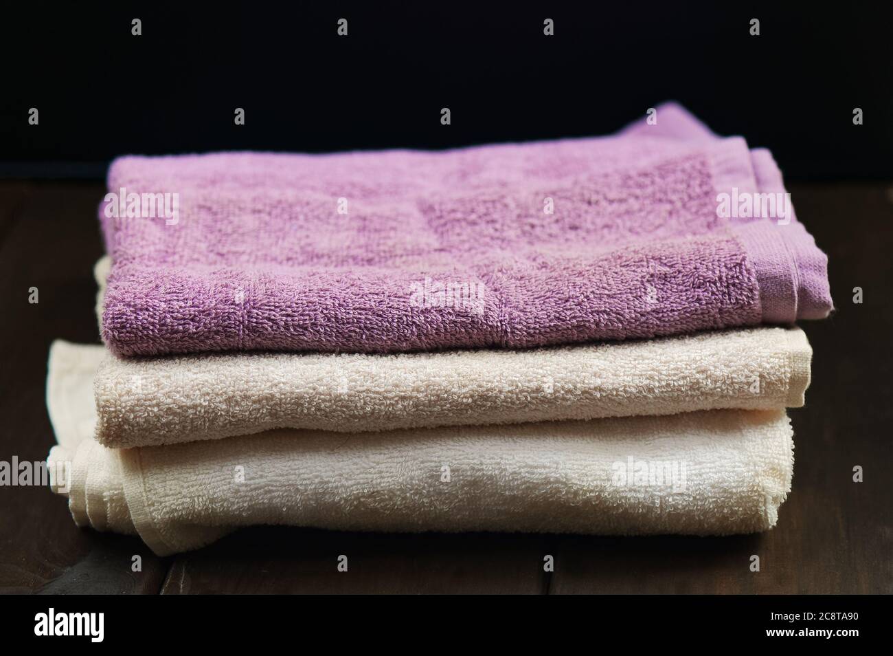 Handtücher auf dunklem Holzhintergrund. Spa-Produkte Stockfoto