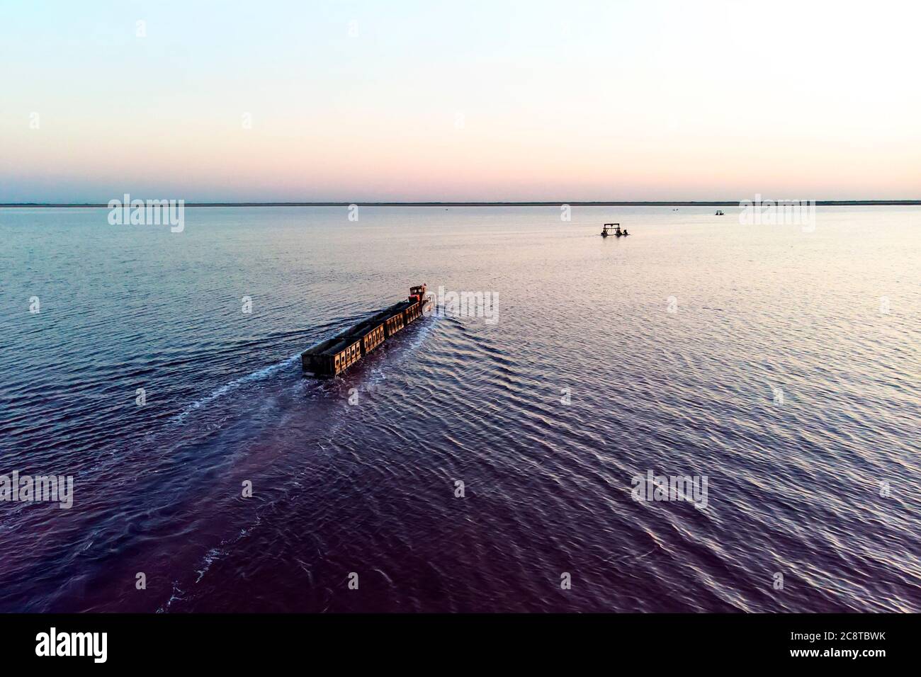 Zug fährt vom Wasser. Abgebaut Salz in Lake Burlin. Altai. Russland. Bursolith. Alte Zugfahrten auf der im Wasser durch den Salzsee gelegten Bahn Stockfoto