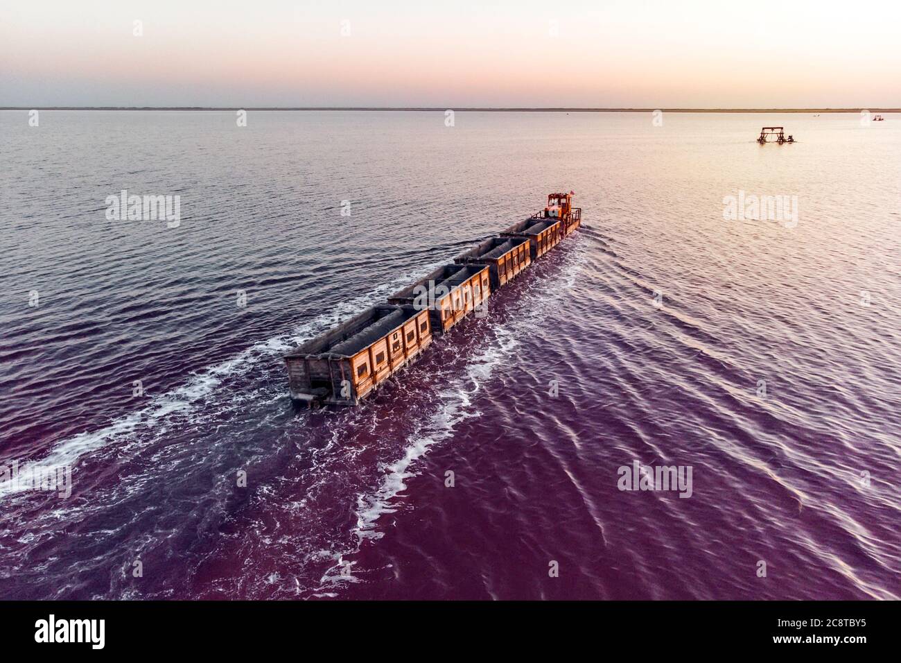Zug fährt vom Wasser. Abgebaut Salz in Lake Burlin. Altai. Russland. Bursolith. Alte Zugfahrten auf der im Wasser durch den Salzsee gelegten Bahn Stockfoto