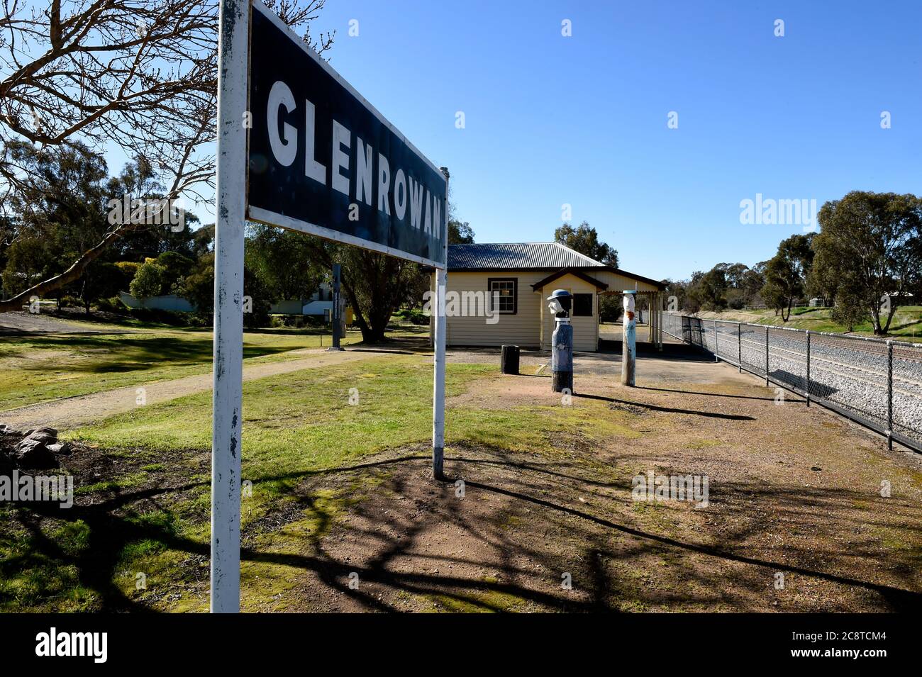 Glenrower, Victoria. Glenrowan Bahnhofsplattform mit Bahnhofschild in Richtung Bahnhofsgebäude, die Holzstatuen markieren die Position der Polizei. Stockfoto