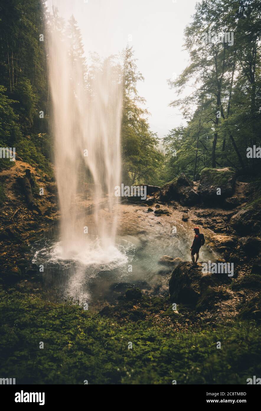 Mann steht im Sommer in der Nähe des großen Wasserfalls in Österreich - Wildensteiner Wasserfall in Kärnten Stockfoto