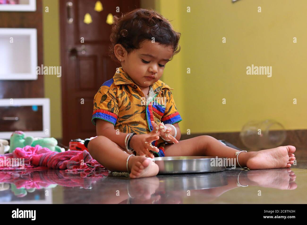 Ein Kind, das auf Essen auf einem Teller schaut Stockfoto
